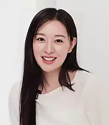 Kim in a white dress in white background.