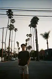 Man standing in front of palms in Los Angeles