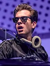 Mark Ronson wearing black shades and with a headphone around his neck.