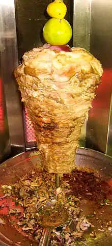 A cook slices ingredients into a skillet