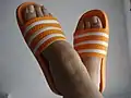 Woman wearing Adidas orange slides
