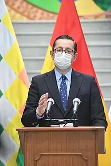 Oscar Ortiz delivers a press conference while wearing a surgical mask.