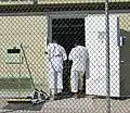 Two detainees in white "uniforms" stand in the doorway of their bay in Camp 4. To a certain extent, a detainee's level is determined by where he is housed, as well. Most Level 1 detainees are afforded extra privileges in Camp 4.