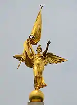 Golden statue of a female angel figure with flag
