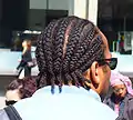 A man with his hair in cornrows.