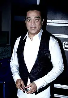 Kamal Haasan, in black and white attire, looks at the camera