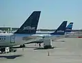 3 JetBlue aircraft at JFK. All JetBlue planes have a different tail design.