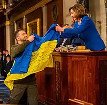 Nancy Pelosi unfolding a Ukrainian flag from the Battle of Bakhmut, at the end of Zelenskyy's speech in the United States Capitol, in December 2022