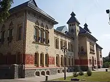 Photograph of a Ukrainian building with ornate tile and brick work on the façade, columned window dressings, and multiple towers