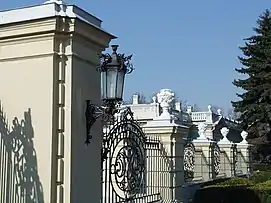 The palace is surrounded by intricate iron railings.