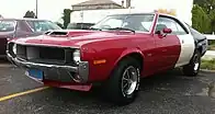 Shows the front quarter of a 1970 Javelin Trans-Am finished in the factory red/white/blue paint scheme