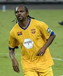 A footballer wearing an orange kit.