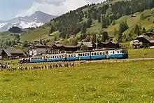 Metre-gauge electric twin motor coach ABDe 8/8 4004 of the Montreux–Lenk im Simmental line in Switzerland pulling two coaches and two cement wagons