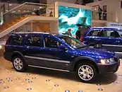 Passenger side view of blue XC70 OR with silver door trim, rocker trim and roof rails