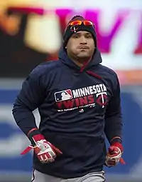 A baseball player wearing a navy blue hoodie