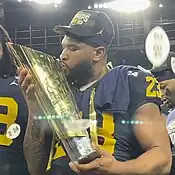 A football player kissing a trophy