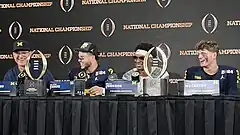 Football players and coaches giving a press conference