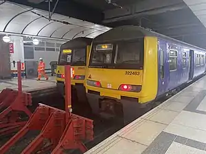 Two trains parked on two platforms. The photo is of the last vehicles of two trains next to each other.