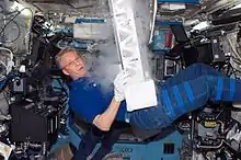 European Space Agency (ESA) astronaut Thomas Reiter, STS-116 mission specialist, works with the Passive Observatories for Experimental Microbial Systems in Micro-G (POEMS) payload in the Minus Eighty Degree Laboratory Freezer for ISS (MELFI) in the Destiny laboratory of the International Space Station while Space Shuttle Discovery was docked with the station. MELFI is a low temperature freezer facility with nominal operating temperatures of -80, -26 and +4 °C that will preserve experiment materials over long periods.