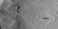 Glacier on a crater floor, as seen by HiRISE under HiWish program The cracks in the glacier may be crevasses.  There is also a gully system on the crater wall.  Location is Casius quadrangle.