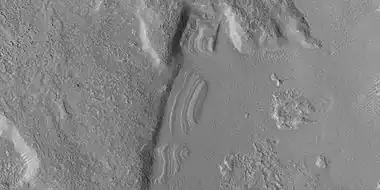 Close view of dipping layers along a mesa wall, as seen by HiRISE under HiWish program Location is Ismenius Lacus quadrangle.