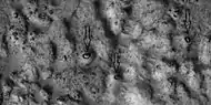 Close view of ejecta, as seen by HiRISE under HiWish program.  Note:  Arrows show examples of boulders sitting in pits.