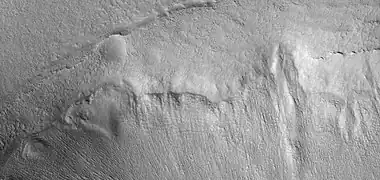 Mantle and mantle layers, as seen by HiRISE under HiWish program.  To the left part of the picture mantle layers seem to have formed dipping layers.