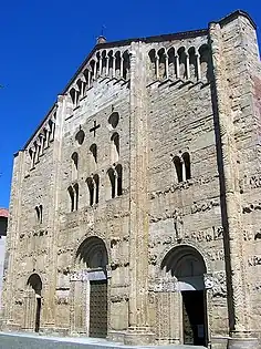 San Michele Maggiore, Pavia, The façade has the form of  screen, higher than the central nave, with a blind arcade below its roofline. It is divided into three bays by buttresses, has a variety of window openings, and horizontal bands of sculptural decoration.