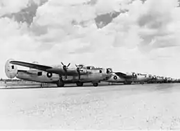 A row of four-engined military aircraft parked on an airfield