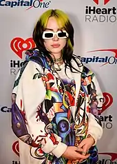 Flashy multi-colored clothing became a trend in the early 2020s, as did baggier clothing such as hoodies, modeled here by musician Billie Eilish. The 2020s revived and built upon Y2K fashion trends.