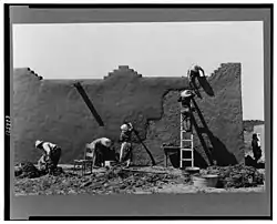 Remudding an adobe wall in Chamisal, circa 1940. Photo: Russell Lee