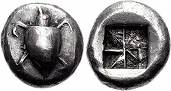 Both sides of a silver coin.  One side has a relief of a turtle; the other the impression of a square divided into eight segments.