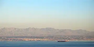 Haql seen from the sea, with the Midian Mountains in the background