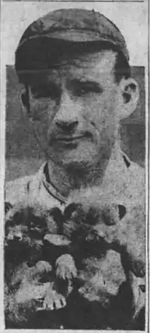 Alabama Pitts in a baseball uniform holding two cub team mascots.