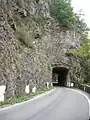 One of the five tunnels in the upper canyon wall