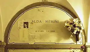 A marble gravestone on the wall of a crypt