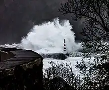 A wave crashing against a rocky escarpment