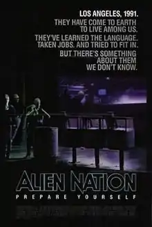 A black poster. Above in bold letters are the lines: "Los Angeles, 1991." "They have come to earth to live among us." "They've learned the language." "Taken jobs." "And tried to fit in." "But there's something about them we don't know." Below, in large typeface is the line: "Alien Nation" and in smaller typeface, the line: "Prepare Yourself," with the film credits underneath. In the background are three extraterrestrials standing on a street corner. One of the figures is a female standing next to a waste basket and three newspaper stands, holding a jacket over her shoulders. Behind her is a bar that features alien typography on its walls. Two extraterrestrials who are hanging out inside the bar, can be seen through its glass window.