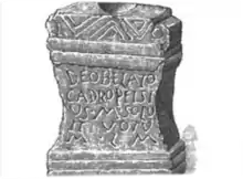 A black and white drawing of a stone block with a Latin inscription.