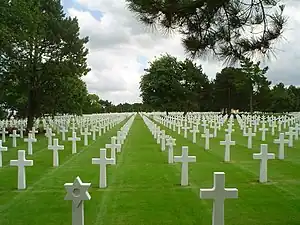 A photograph of white grave markers on green grass at the Normandy American Cemetery and Memorial near Omaha Beach in France