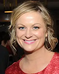 A smiling blond woman wearing a black dress.