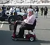 Andy Grantelli on a mobility scooter in the pit lane of a race track