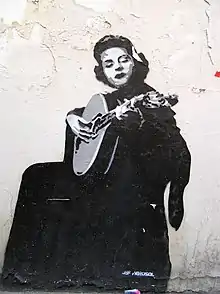 Mural of a seated Amália Rodrigues playing a lute-like instrument