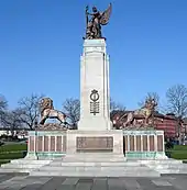 A column flanked by two lions and surmounted by a statue of Peace and a soldier. There are bronze plaques on the base of the monument.