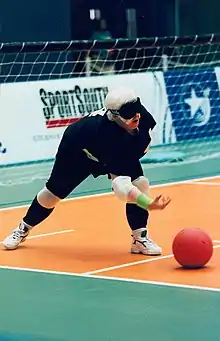 A goalballer throws the ball forward.