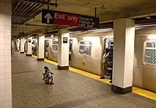 The Brighton Line platform at the Atlantic Avenue station. There is a "Q" train at right.