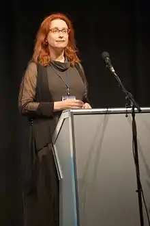 Photograph of Audrey Niffenegger standing behind a lectern, delivering the inaugural PEN/H.G. Wells lecture at Loncon, Worldcon 2014