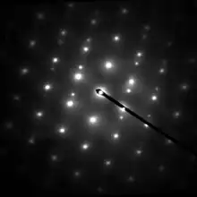 Electron diffraction pattern showing white spots on a dark background, as a general example.