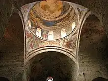 Photograph of a church dome covered with frescoes. From inside the building.