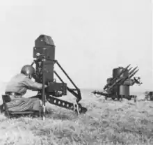 A two-wheeled trailer with four missiles on it. It has a radar dome, and a jerry can is attached to the trailer.